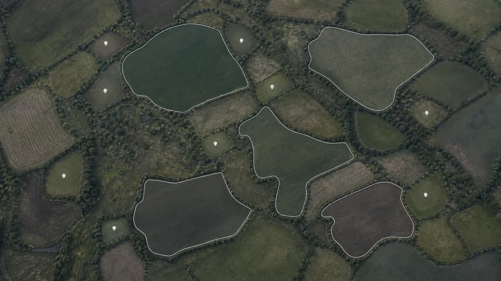 Farm plots seen from above, some marked with a single coordinate pin and larger ones traced with a full boundary line